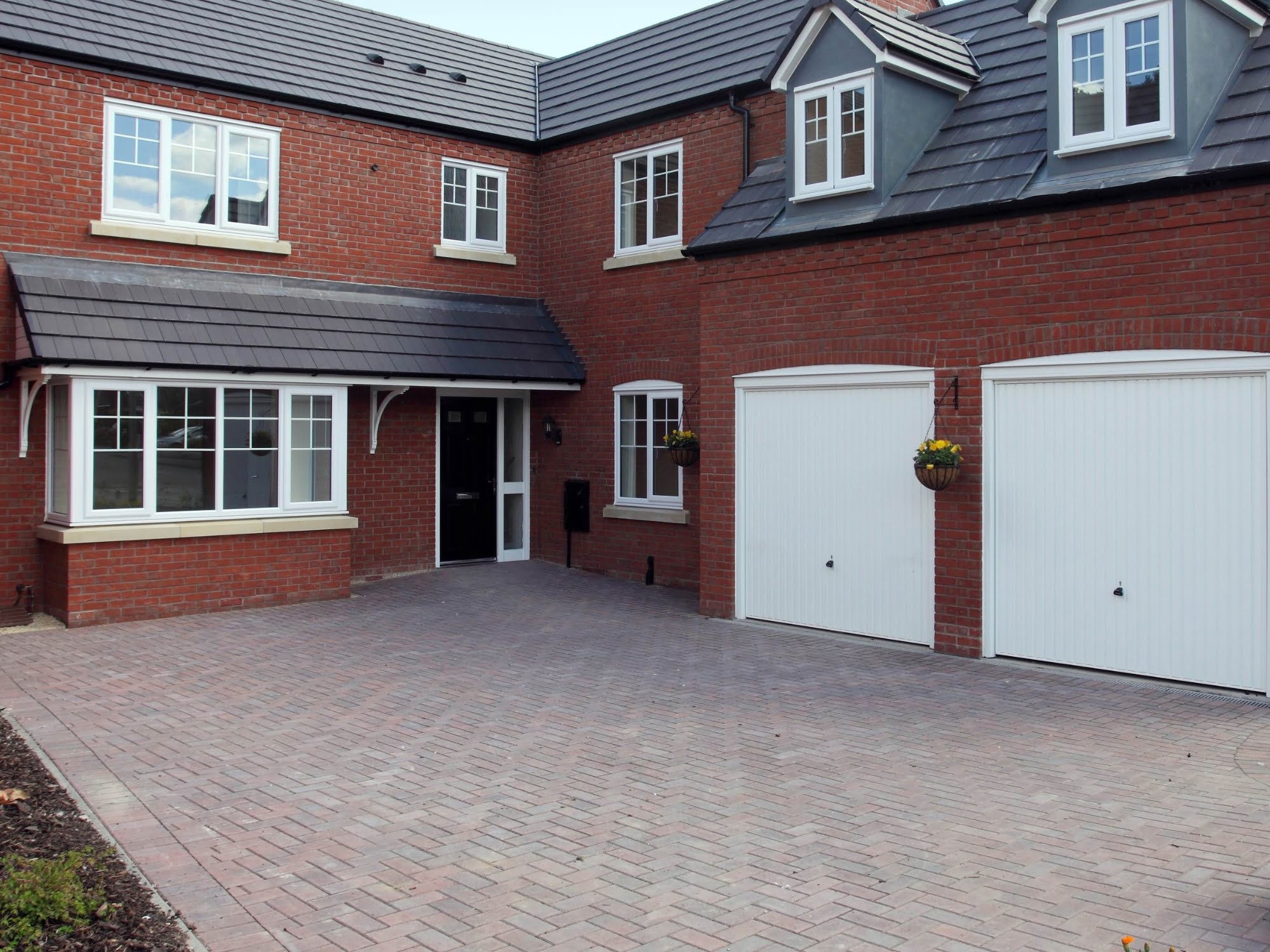 An image of a detached house with a large driveway